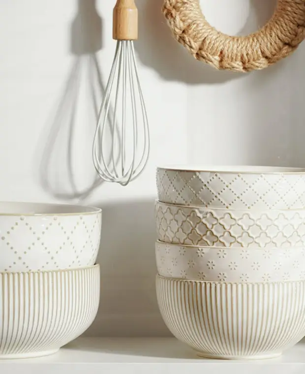Stacked Getstar ceramic bowls with embossed diamond, quatrefoil and ribbed patterns on a white kitchen shelf